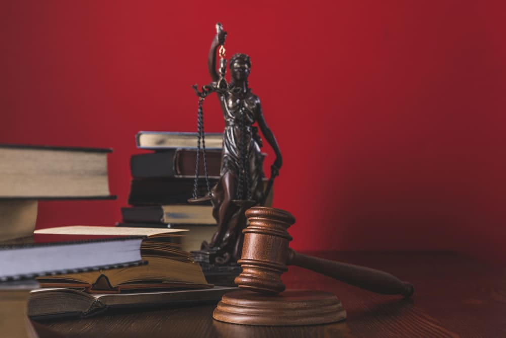 Image shows law books, a gavel, and a justice statue on a desk, concept of courtroom procedures and legal representation in Lebanon TN.