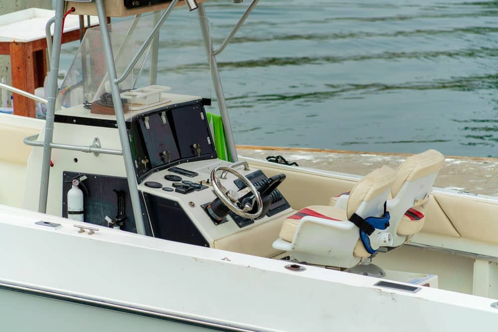 Image shows a boat’s steering console and captain’s seating area near the dock, concept of boating operation and impaired boating investigations.