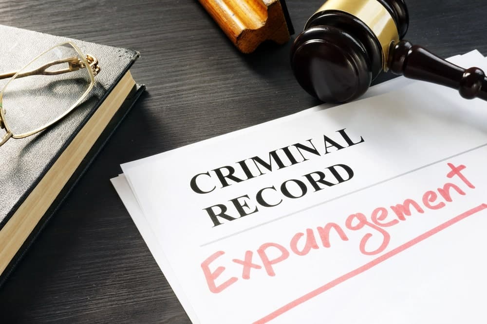 Image shows criminal record paperwork marked for expungement with a gavel nearby, illustrating how an expungement lawyer works to remove prior charges.