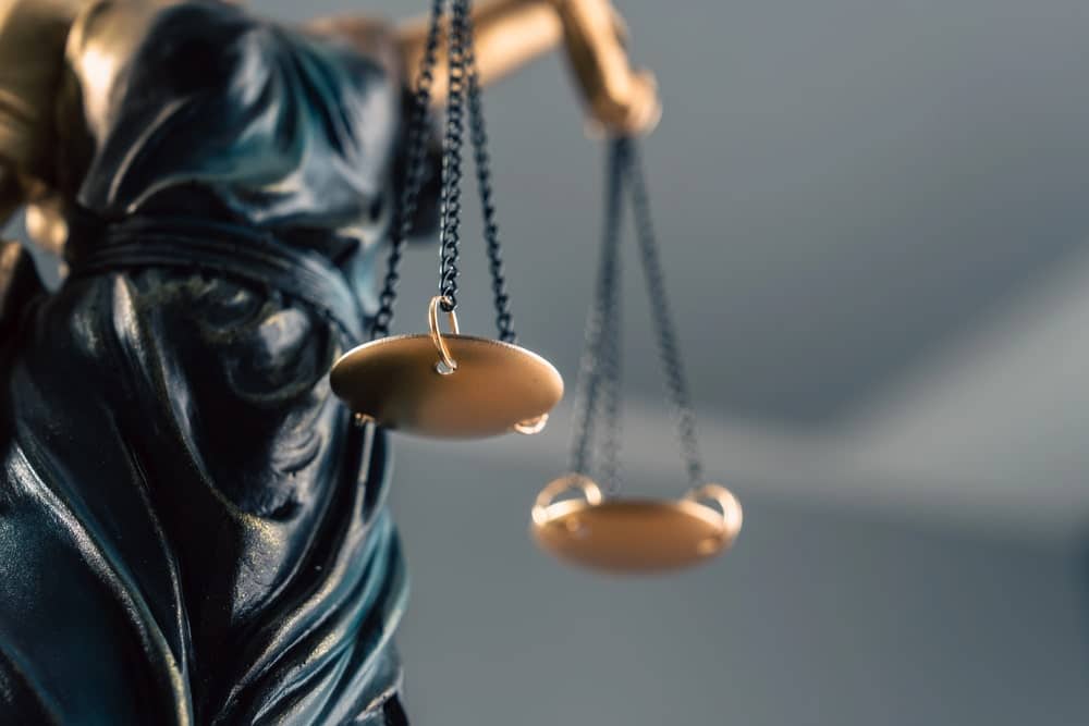 Image is of the scales of justice in a courtroom setting, representing the legal defense strategies a theft lawyer may use when protecting a client’s rights.
