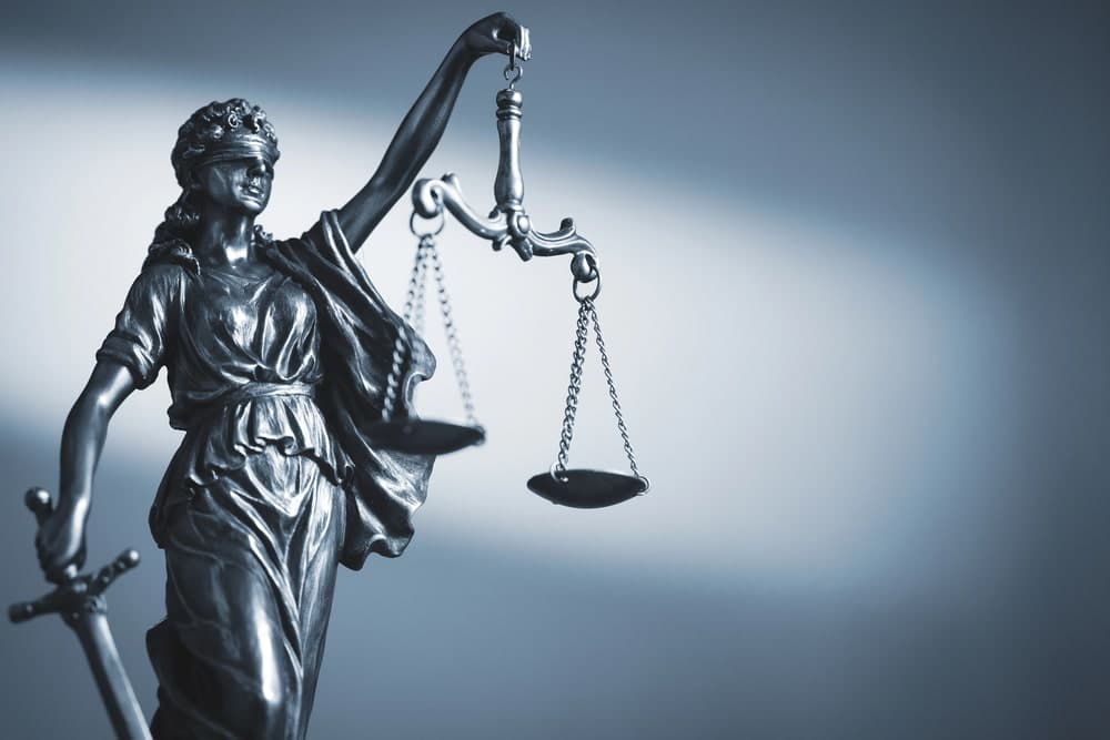Image is of a Lady Justice statue holding balanced scales, illustrating how the legal system responds to a domestic violence arrest in Lebanon.