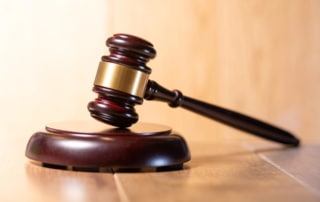 Image is of a judge’s gavel resting on a desk, symbolizing court decisions and legal authority involved in domestic violence charges.