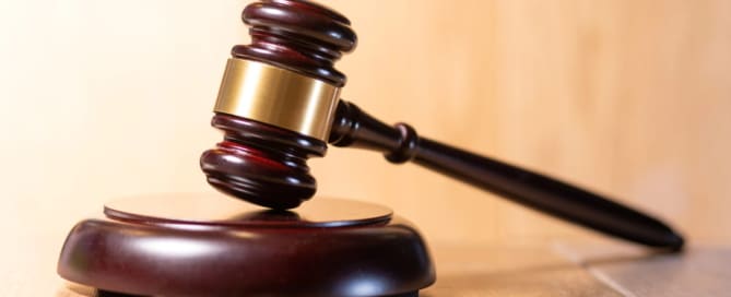 Image is of a judge’s gavel resting on a desk, symbolizing court decisions and legal authority involved in domestic violence charges.