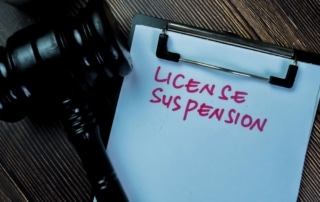 Image is of a court clipboard and gavel highlighting DUI license suspension procedures and legal consequences tied to driving privileges.