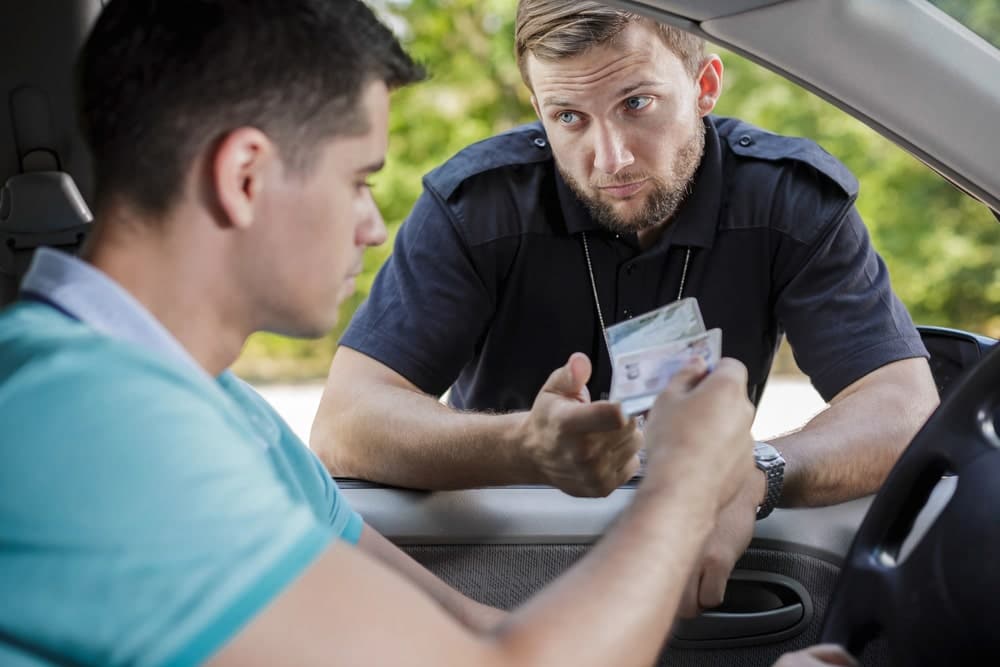 Image is of a police officer reviewing identification during a traffic stop, illustrating DUI arrest procedures connected to Tennessee DUI sentencing.