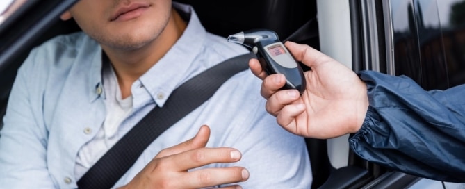 Image is of a driver being asked to take a breathalyzer during a roadside stop, concept of a breath test in Tennessee