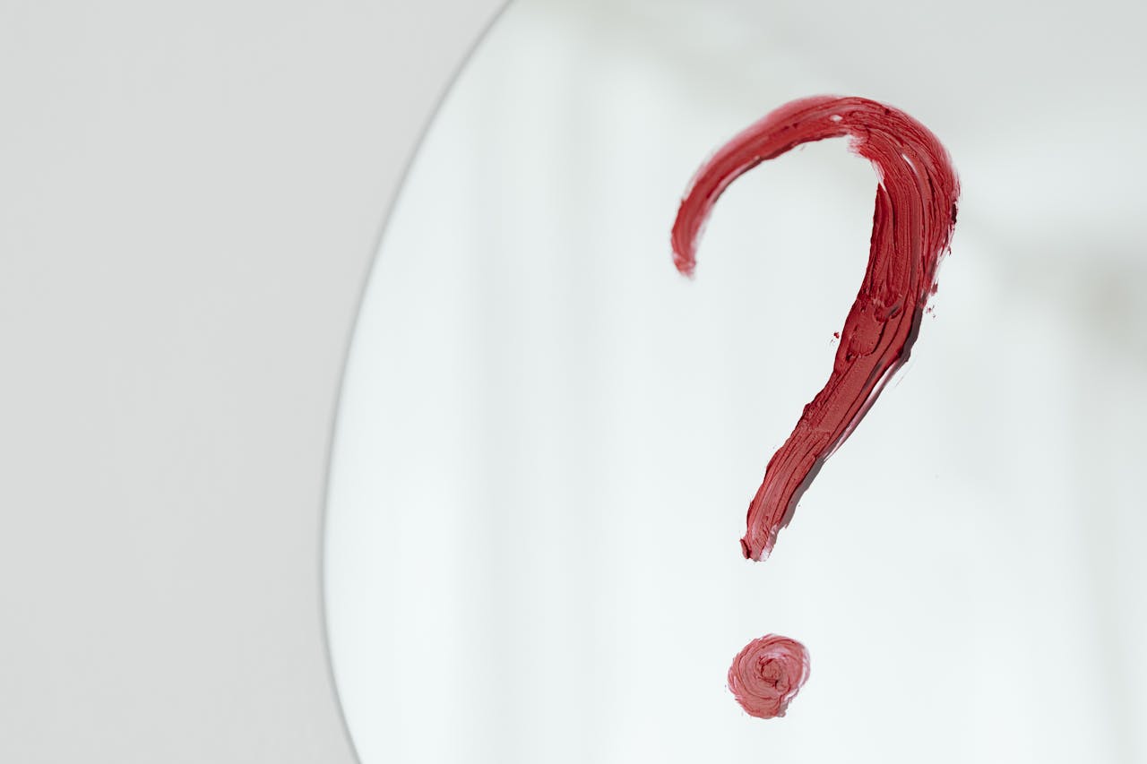 Image is of a red question mark painted on a white surface, concept of confusion surrounding consent laws in Tennessee and what legally counts as consent.