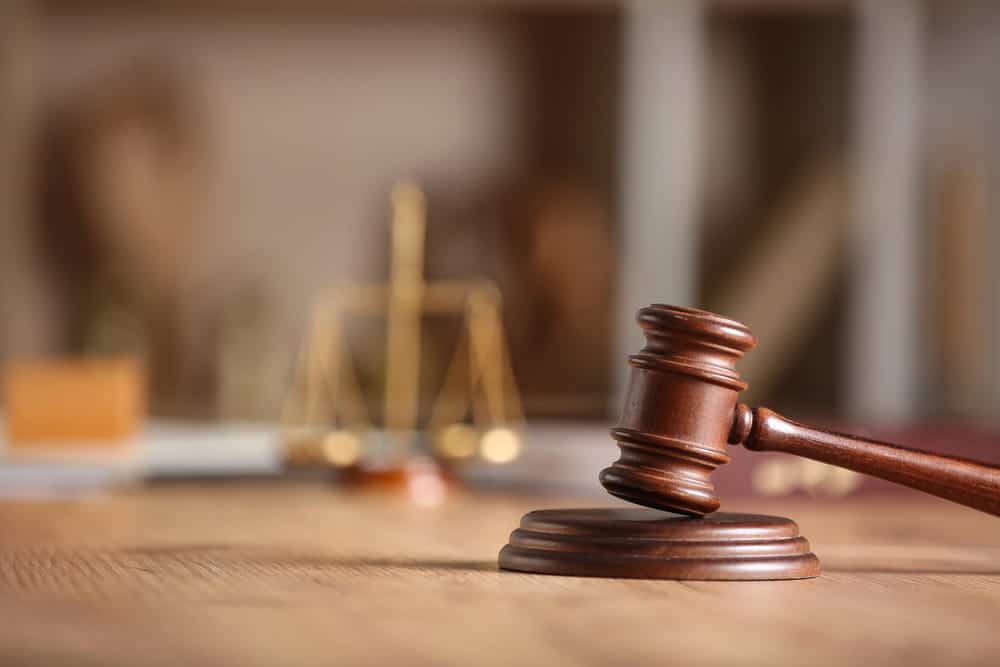 Image is of a judge’s gavel on a desk with scales of justice in the background, concept of legal consequences after a drug arrest in Lebanon