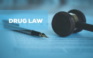 Image of a wooden gavel and fountain pen resting on a legal document, illustrating how drug schedules impact criminal defense cases.
