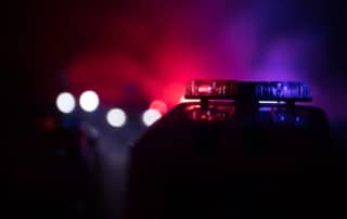 Image is of flashing police lights during a traffic stop at night, illustrating how DUIs affect penalties after a suspected impaired driving arrest.