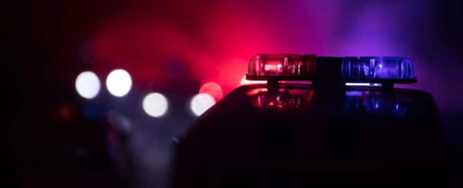 Image is of flashing police lights during a traffic stop at night, illustrating how DUIs affect penalties after a suspected impaired driving arrest.
